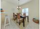 Comfortable dining area featuring a dark wood table, wicker chairs, and a stylish chandelier at 632 Golf Dr # 632, Venice, FL 34285