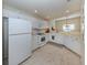 Bright kitchen featuring white appliances, tile flooring, and ample cabinet space at 632 Golf Dr # 632, Venice, FL 34285