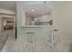 Open kitchen view featuring white cabinets, counter seating, and modern appliances at 632 Golf Dr # 632, Venice, FL 34285