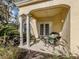 Cozy covered patio with stylish wicker furniture, a glass table, and a view of the lush landscaping at 632 Golf Dr # 632, Venice, FL 34285