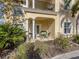 Inviting covered patio area with elegant columns, comfortable seating, and views of the surrounding greenery at 632 Golf Dr # 632, Venice, FL 34285