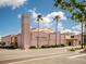 The Venice Theatre featuring a striking exterior with a pink facade, tower, and palm tree landscaping at 632 Golf Dr # 632, Venice, FL 34285