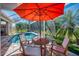 Beautiful pool area inside a screened lanai with an outdoor dining table at 647 Pond Willow Ln, Venice, FL 34292