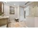 Elegant bathroom featuring a classic vanity, decorative mirror, and a glass-enclosed shower with neutral stone tile at 704 Laguna Dr, Venice, FL 34285