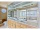 Well-lit bathroom featuring double sinks, a large mirror, a bathtub, and a separate shower at 715 Golden Beach Blvd, Venice, FL 34285