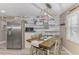 Dining area with stainless steel appliances, modern light fixture, and wood-style decor at 720 Apalachicola Rd # 104, Venice, FL 34285