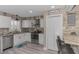 Well-lit kitchen featuring white cabinets, stone backsplash, and stainless steel appliances with bar stool seating at 720 Apalachicola Rd # 104, Venice, FL 34285