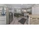 Well-lit kitchen with stainless steel appliances, stone countertops, and dining area with a coastal decor at 720 Apalachicola Rd # 104, Venice, FL 34285
