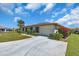 Single-story home featuring a concrete driveway, well-manicured lawn, and colorful, mature landscaping at 761 Vivienda South Ct # 14, Venice, FL 34293