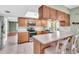 Modern kitchen with stainless steel appliances, wooden cabinets, and a breakfast bar, perfect for casual dining at 761 Vivienda South Ct # 14, Venice, FL 34293