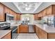 Well-appointed kitchen featuring stainless steel appliances, wood cabinetry, and ample counter space for cooking at 761 Vivienda South Ct # 14, Venice, FL 34293