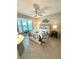 Bedroom featuring a queen bed with tropical floral bedding, a ceiling fan, and natural light at 782 Harrington Lake N Dr # 99, Venice, FL 34293