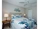 Comfortable bedroom featuring a queen bed with stylish tropical-themed bedding and a ceiling fan at 782 Harrington Lake N Dr # 99, Venice, FL 34293