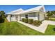 Charming single-story home with well-manicured lawn, white tile roof, and inviting front entrance at 782 Harrington Lake N Dr # 99, Venice, FL 34293