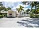Exterior view of the property with palm trees, a parking lot, and a gate at 782 Harrington Lake N Dr # 99, Venice, FL 34293