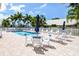 Community pool with seating, tables, lounge chairs, and umbrellas at 782 Harrington Lake N Dr # 99, Venice, FL 34293