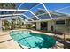Outdoor pool within screened enclosure with patio and chairs on the back of home with sliding glass doors at 782 Harrington Lake N Dr # 99, Venice, FL 34293