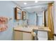 Bathroom featuring vanity, sink, toilet, cabinets, and a shower with gold tiles at 820 Capri Isles Blvd # 202, Venice, FL 34292