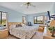 Bright bedroom with a large bed, two windows offering picturesque outdoor views, and a ceiling fan at 820 Capri Isles Blvd # 202, Venice, FL 34292