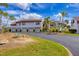 Waterfront condo building featuring a large, lush green area with palm trees and meticulously maintained landscaping at 820 Capri Isles Blvd # 202, Venice, FL 34292