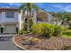 Well maintained condo building with tropical plants, landscaping, and manicured lawn at 820 Capri Isles Blvd # 202, Venice, FL 34292