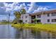 Well-maintained condo exterior with lush landscaping and a peaceful lakeside setting at 820 Capri Isles Blvd # 202, Venice, FL 34292