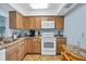 Kitchen with wood cabinets, white appliances, and a dining area at 820 Capri Isles Blvd # 202, Venice, FL 34292