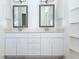 Well-lit bathroom featuring double sinks, mirrors, and white cabinetry at 835 Chalmers Dr # 835, Venice, FL 34293