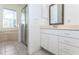 Bright bathroom showcasing a white vanity with a framed mirror, tiled floor, and a glass shower at 835 Chalmers Dr # 835, Venice, FL 34293