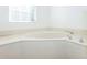 This bathroom features an inviting soaking tub with chrome hardware and a sunny window at 835 Chalmers Dr # 835, Venice, FL 34293