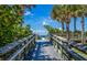 Elevated boardwalk provides easy access to the beach, nestled amidst lush tropical greenery at 835 Chalmers Dr # 835, Venice, FL 34293
