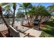 Outdoor grilling area near the pool, shaded by palms, with seating and a stainless steel grill at 835 Chalmers Dr # 835, Venice, FL 34293