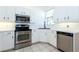 Modern kitchen with white cabinets, stainless appliances and tile flooring at 835 Chalmers Dr # 835, Venice, FL 34293
