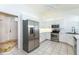 Bright kitchen with white cabinets, stainless steel appliances, tile flooring, and doorway to front entrance at 835 Chalmers Dr # 835, Venice, FL 34293