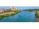 Scenic view of a waterway with a passing boat, condos, lush greenery, and a bridge in the background at 835 Chalmers Dr # 835, Venice, FL 34293