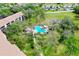 Aerial view of condo complex and community pool surrounded by lush greenery and mature trees at 838 Bird Bay Way # 114, Venice, FL 34285