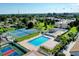 Aerial view of community with pool, tennis courts and lush green landscaping at 838 Bird Bay Way # 114, Venice, FL 34285