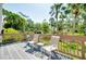 Outdoor deck space featuring seating, a small table, and a view of lush landscaping and palm trees at 838 Bird Bay Way # 114, Venice, FL 34285