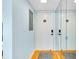 Hallway with mirrored closet doors and hardwood flooring at 838 Bird Bay Way # 114, Venice, FL 34285