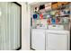 Efficient laundry room with modern washer and dryer, plus overhead storage shelves for supplies at 838 Bird Bay Way # 114, Venice, FL 34285