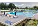 Community pool with ample lounge chairs, umbrellas, and a fence surround at 838 Bird Bay Way # 114, Venice, FL 34285
