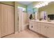 Well-lit bathroom with double sinks, vanity, tiled floors, and shower/tub combo at 921 Tartan Dr # 31, Venice, FL 34293
