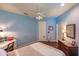 Bright bedroom with a queen bed, desk area, ceiling fan, closet, and bright window with shutters at 921 Tartan Dr # 31, Venice, FL 34293