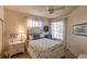 Bright bedroom has a ceiling fan, windows, neutral walls, queen bed, and a matching dresser at 921 Tartan Dr # 31, Venice, FL 34293