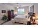 Light-filled bedroom with a queen bed, ceiling fan, shuttered windows and elegant furniture pieces at 921 Tartan Dr # 31, Venice, FL 34293