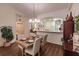 Cozy dining room featuring wood floors, an elegant chandelier, and partial view of the kitchen at 921 Tartan Dr # 31, Venice, FL 34293