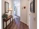 Hallway with wood floors, a decorative table and mirror, and a view of the front door at 921 Tartan Dr # 31, Venice, FL 34293