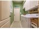 Laundry room featuring white cabinets, laundry machines, sage colored walls, and an outdoor-access door at 921 Tartan Dr # 31, Venice, FL 34293