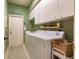 Light-green laundry room features ample cabinet space, appliances, decor, and a rug at 921 Tartan Dr # 31, Venice, FL 34293