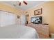 Bright bedroom with a ceiling fan, large closet, and television on a dresser at 9839 Nostalgia Pl, Englewood, FL 34223